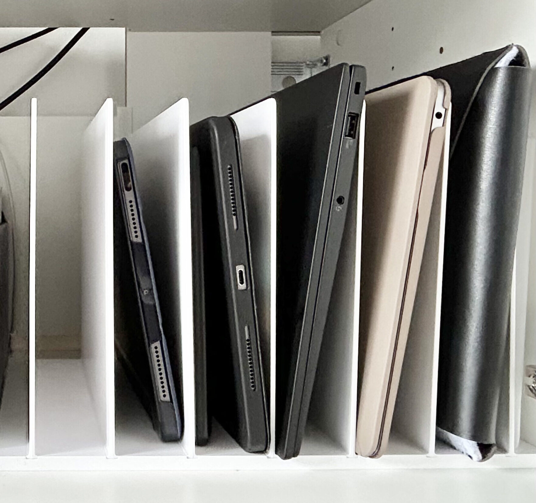 organized laptops and ipads in a vertical divider